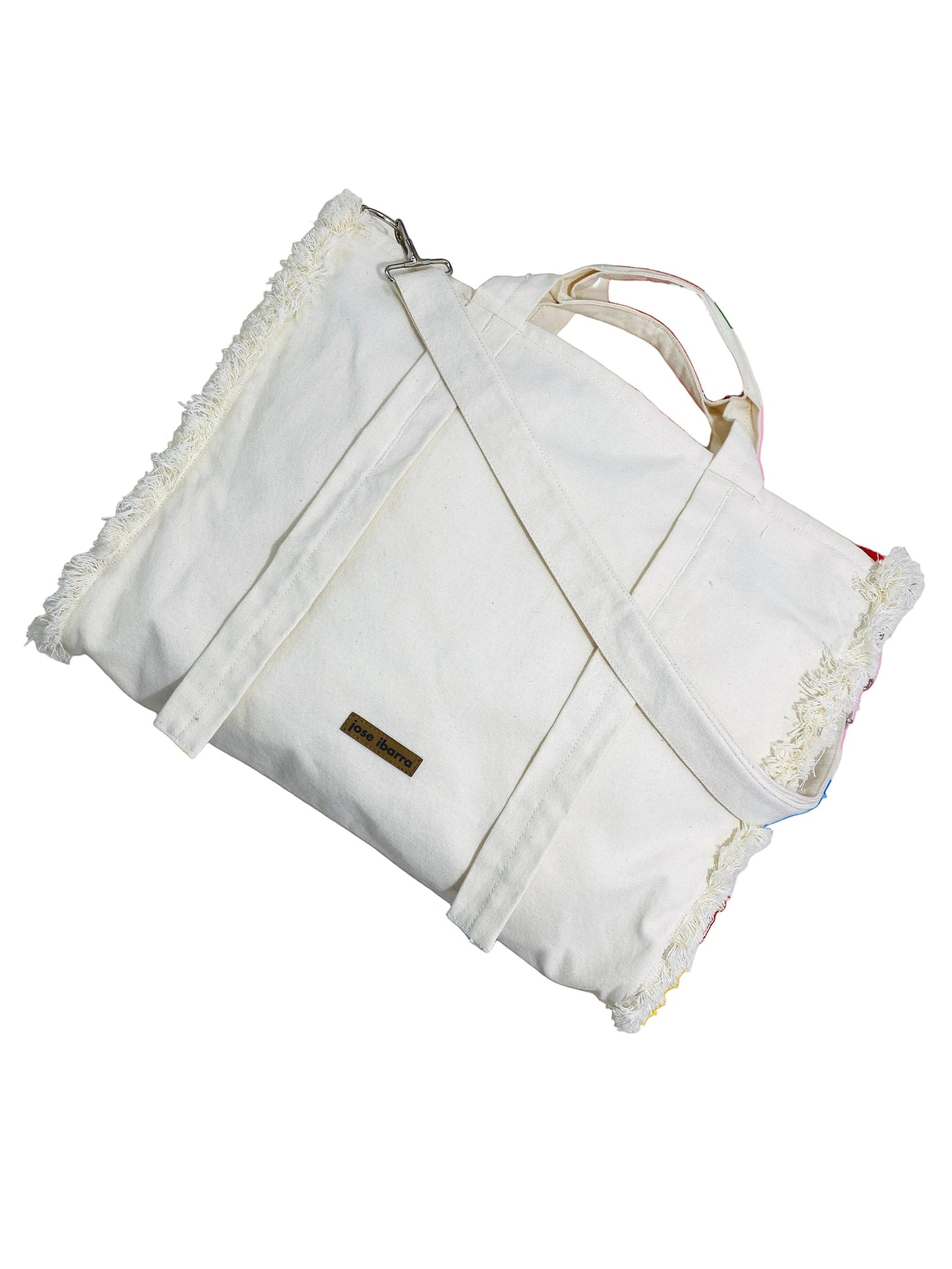 Jose Ibarra Estudio off-white cotton canvas tote bag with hand-painted details and frayed edges. Includes strap.