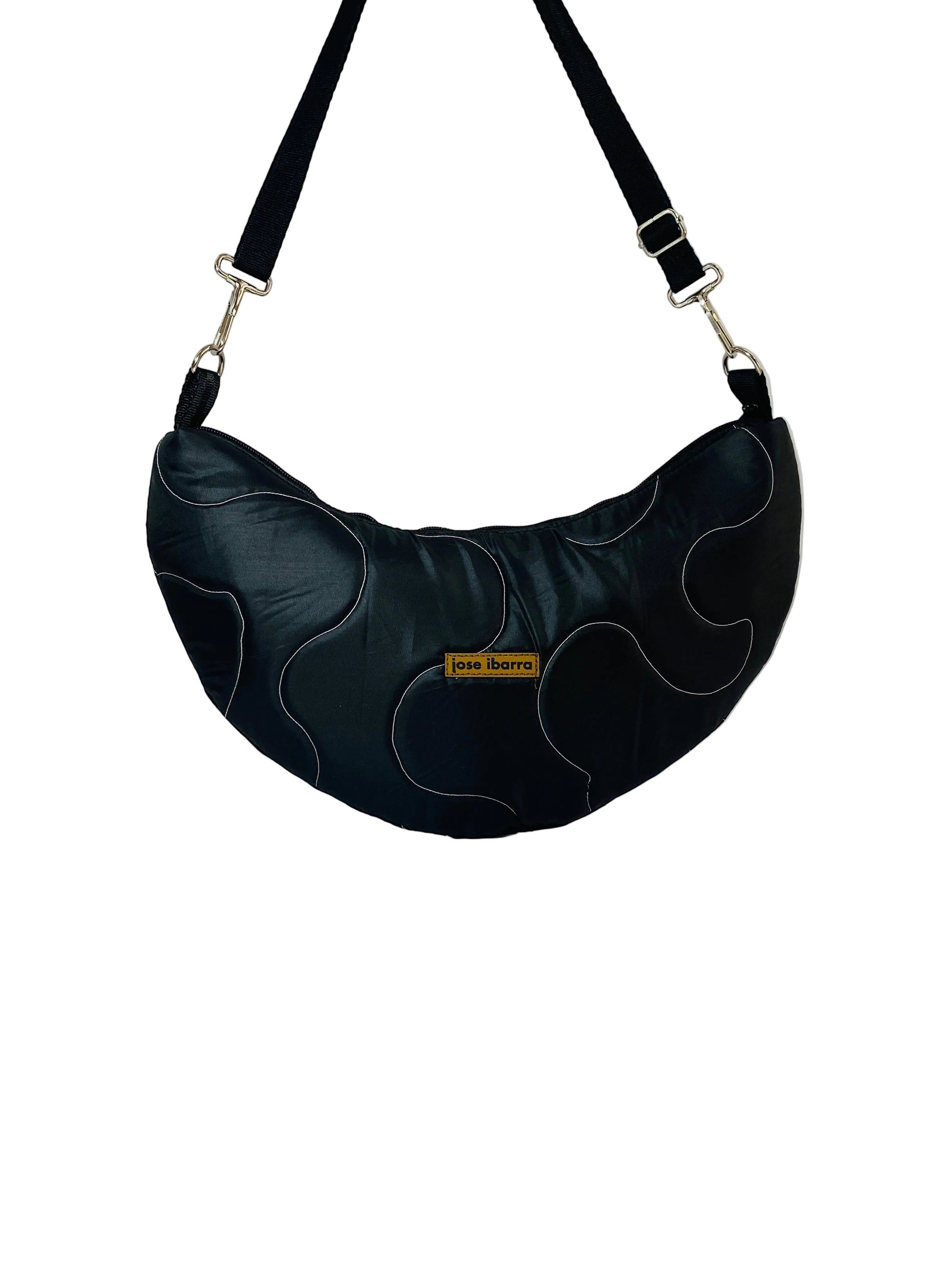 Jose Ibarra black cotton canvas crescent bag with hand-painted abstract design and adjustable strap. Available in two sizes.