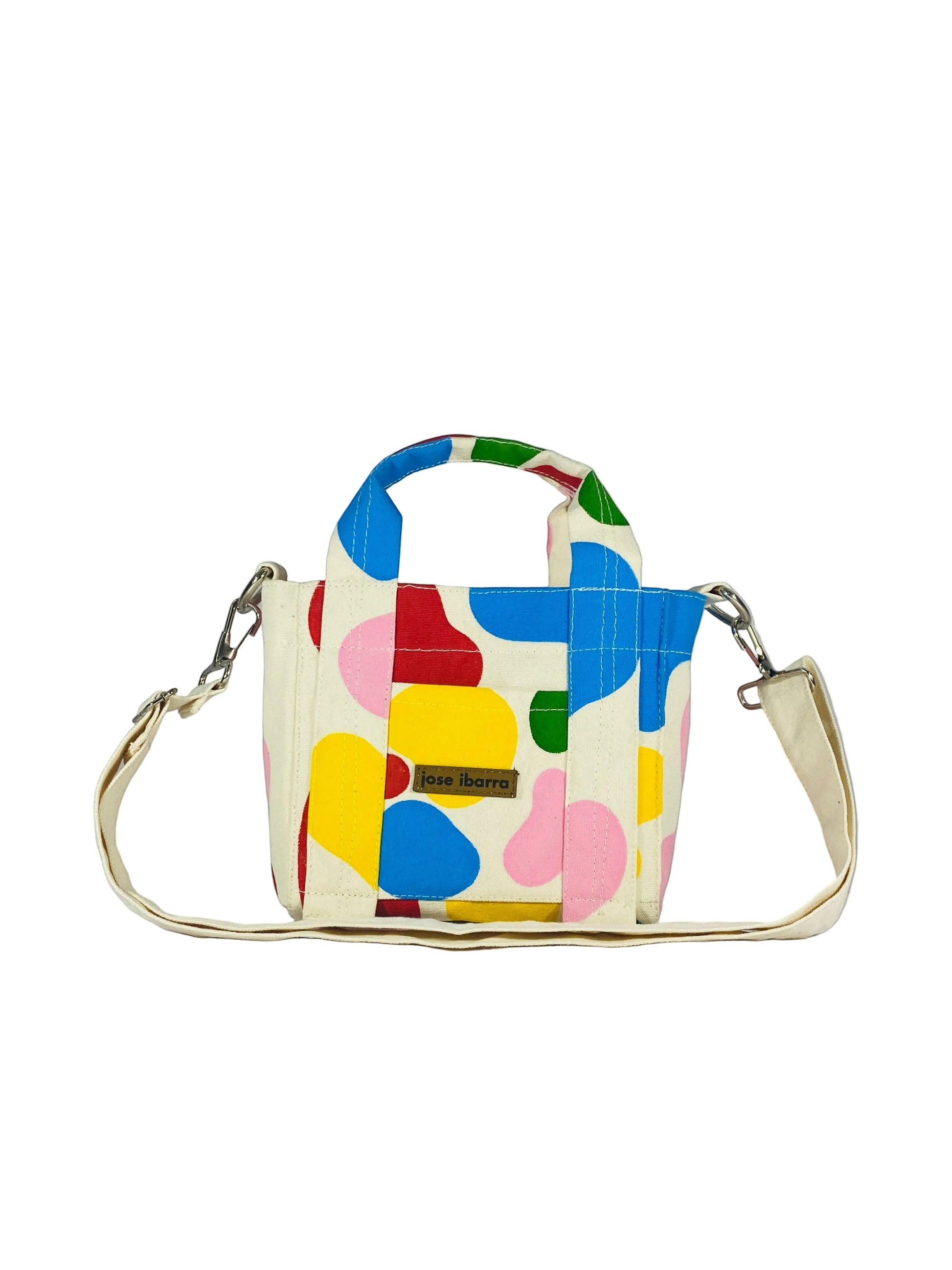 Jose Ibarra small canvas tote bag with colorful abstract hand-painted shapes, dual handles, and detachable strap.