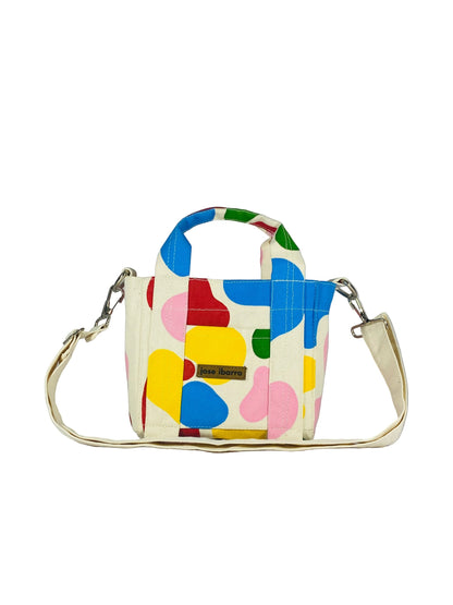 Jose Ibarra small canvas tote bag with colorful abstract hand-painted shapes, dual handles, and detachable strap.