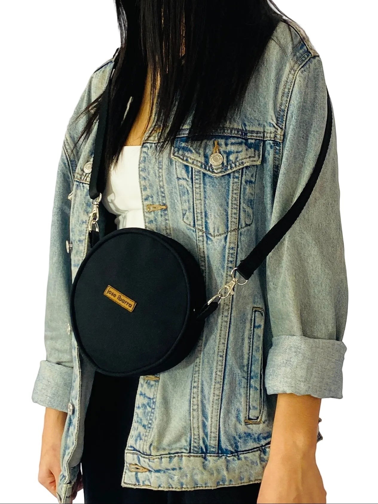 Jose Ibarra Estudio black canvas round crossbody bag with adjustable strap and internal lining. Hand-painted details.