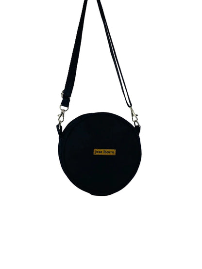 Jose Ibarra Studio black canvas round crossbody bag with adjustable strap and internal lining. 18cm diameter.