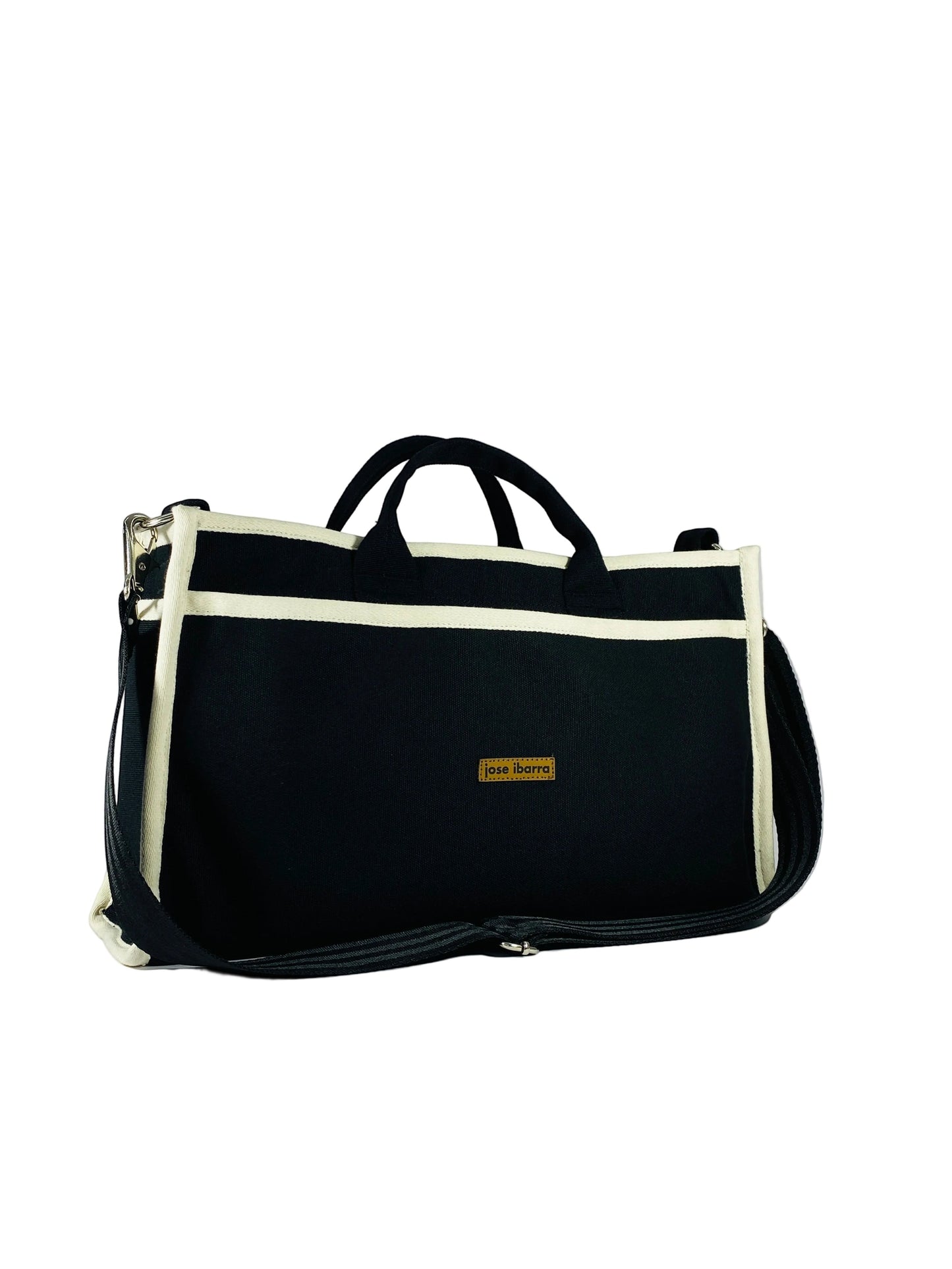 Jose Ibarra Estudio black thick canvas tote bag with cream trim and adjustable strap. Includes internal pockets.