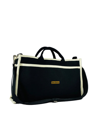 Jose Ibarra Estudio black thick canvas tote bag with cream trim and adjustable strap. Includes internal pockets.