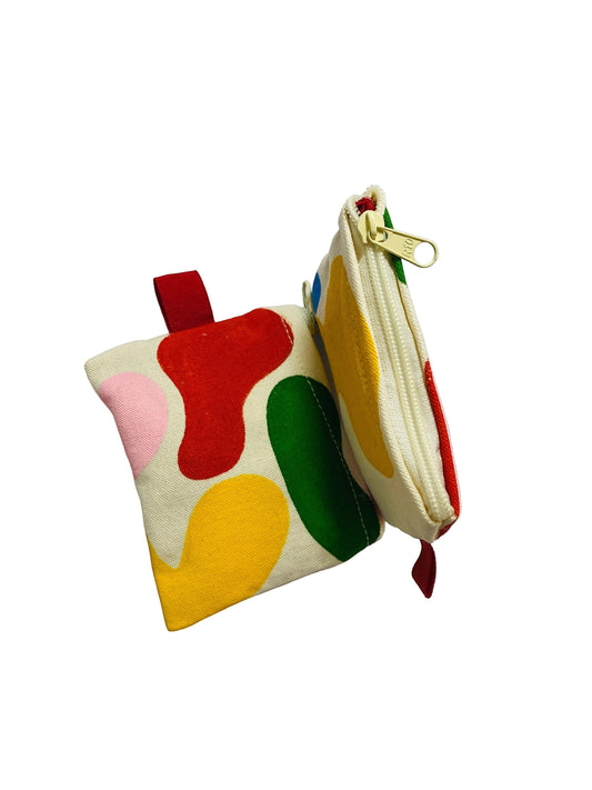 Jose Ibarra Estudio cream canvas coin purse with hand-painted abstract red, yellow, green, and pink shapes. Zipper closure.