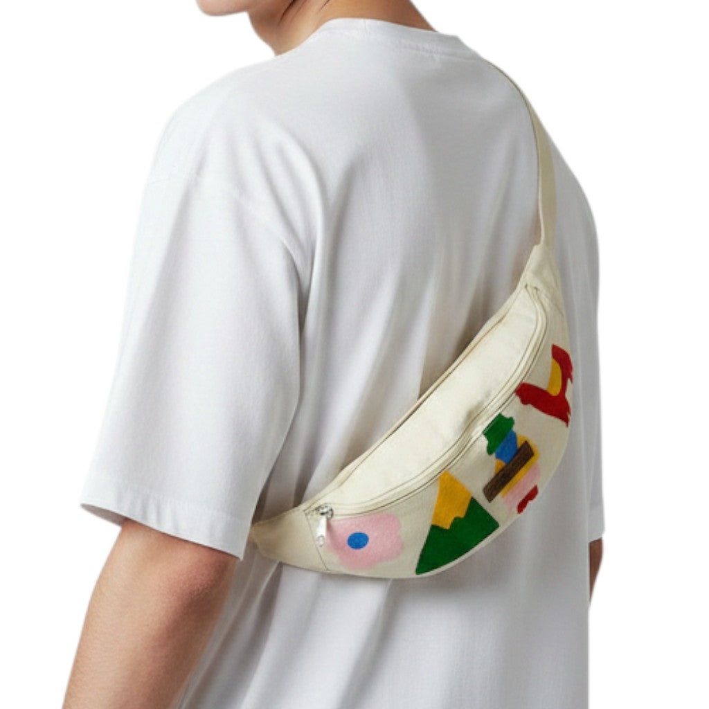 Jose Ibarra Estudio cream canvas fanny pack with colorful hand-painted abstract shapes and mountain motifs. Adjustable strap.