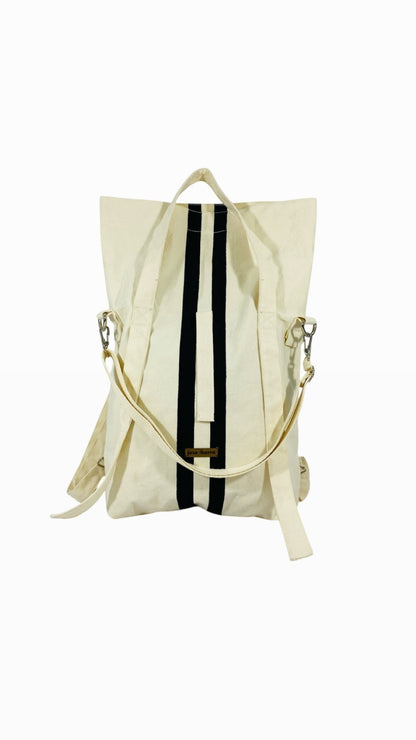Jose Ibarra Estudio cream canvas tote bag with black vertical stripes, convertible to backpack or crossbody.