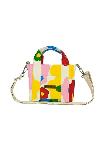 Jose Ibarra Estudio cream canvas tote bag with a colourful hand-painted floral pattern, top handles and adjustable strap.