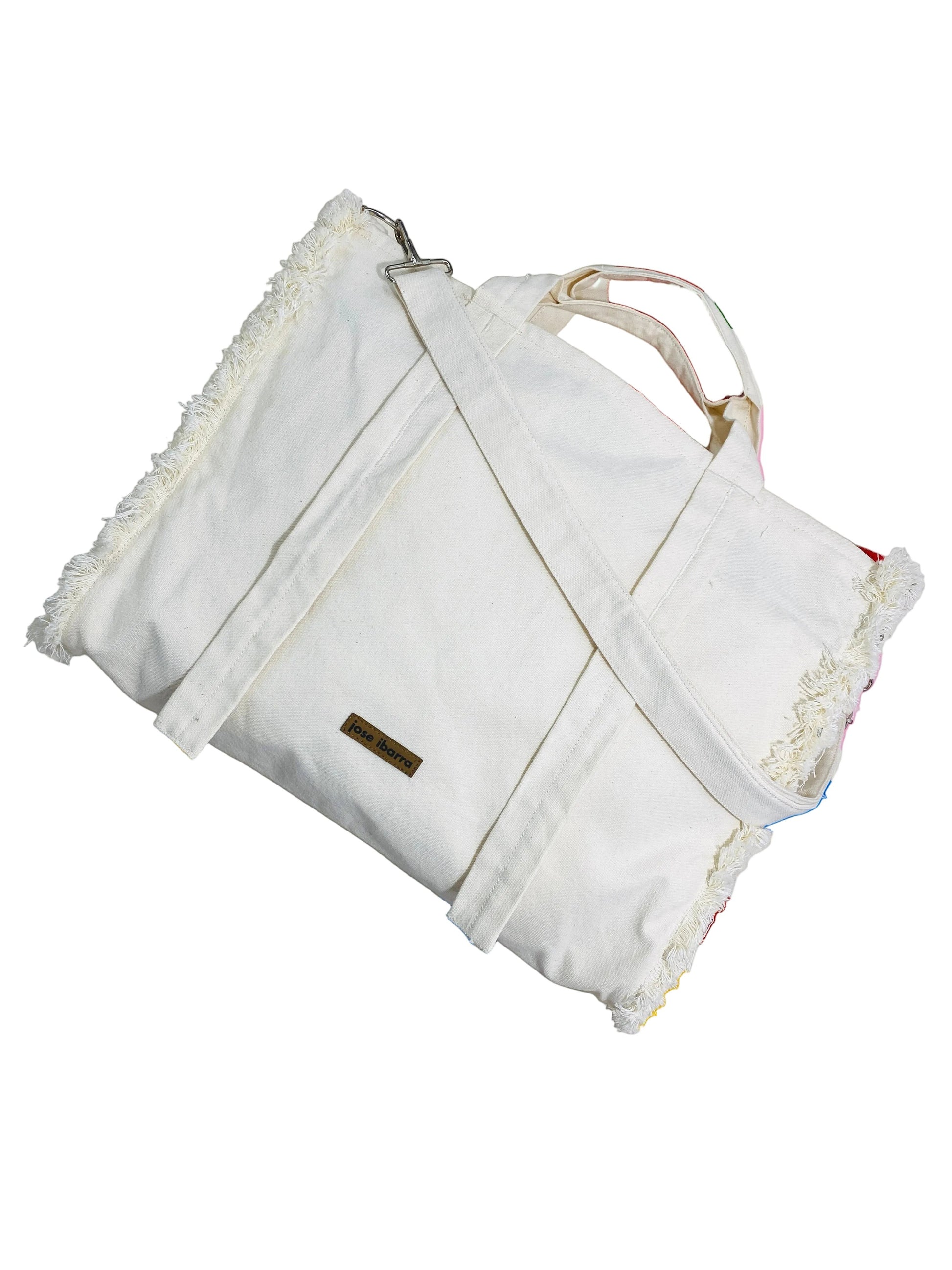 Jose Ibarra Estudio off-white cotton canvas tote bag with hand-painted details and frayed edges. Includes strap.