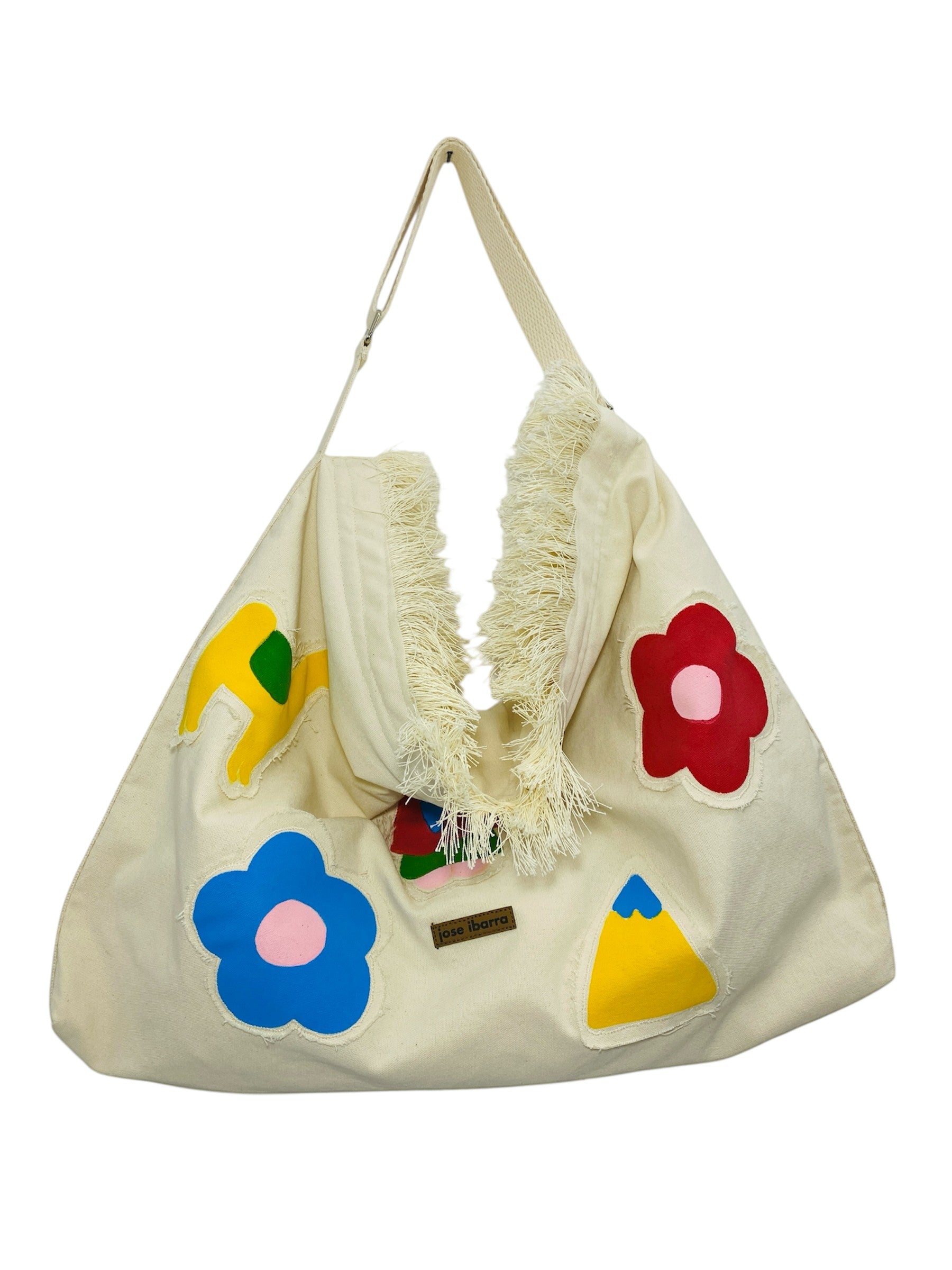 Jose Ibarra Estudio cream cotton canvas tote bag with hand-painted colourful floral and abstract appliques and frayed edges.