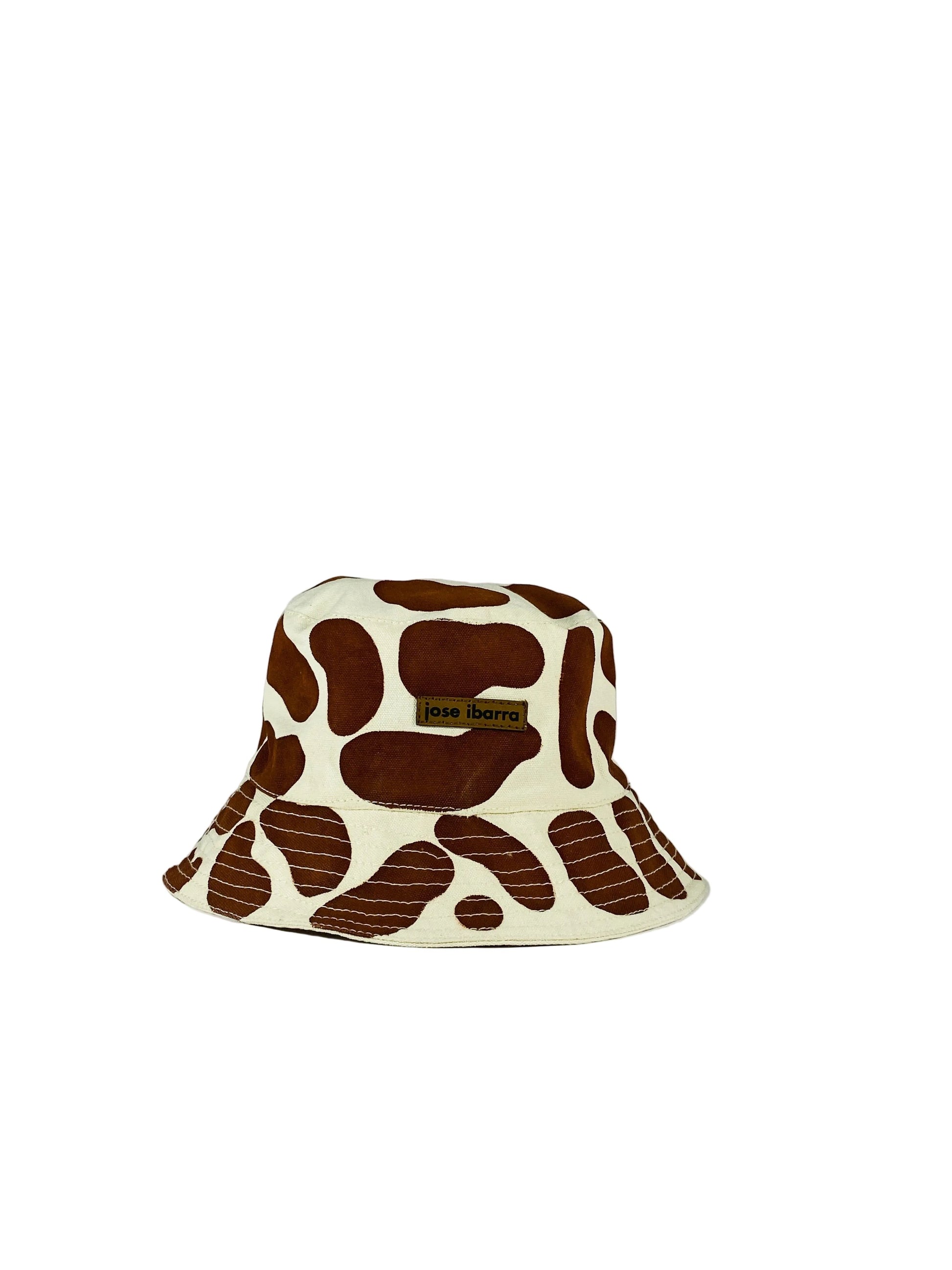 Jose Ibarra Estudio cream bucket hat with brown cow print pattern, thick cotton canvas, hand-painted design.