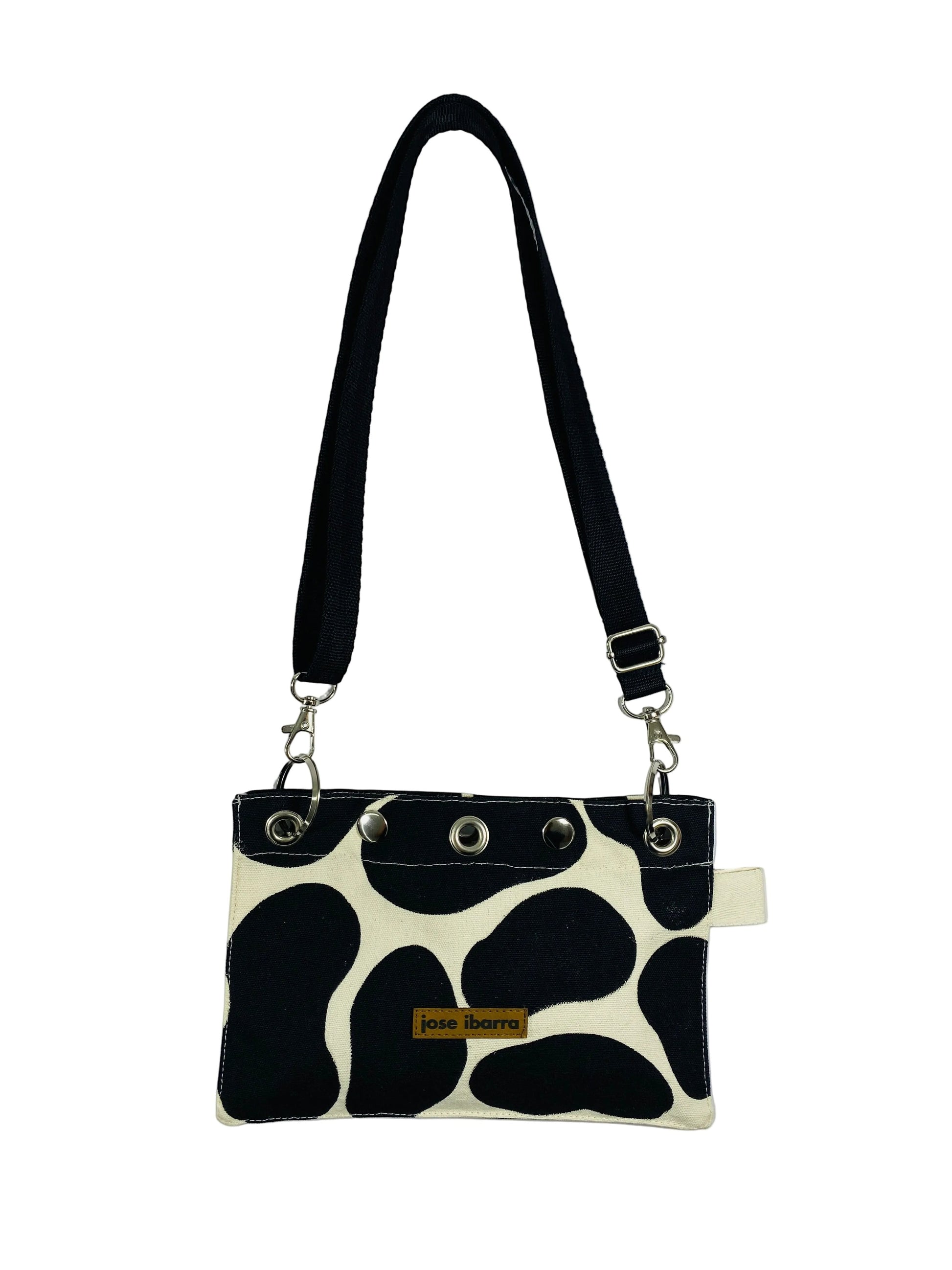 Jose Ibarra Estudio black and white cow print canvas pouch with adjustable strap and internal lining. 23x17 cm.