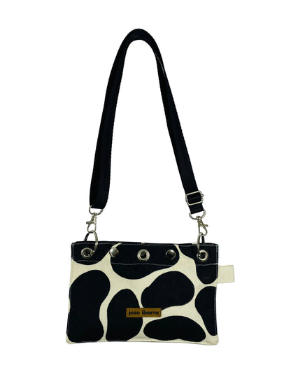 Jose Ibarra Estudio black and white cow print canvas pouch with adjustable strap and internal lining. 23x17 cm.