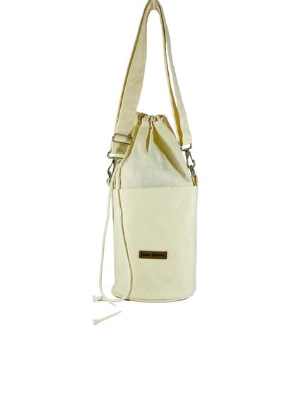 Jose Ibarra Estudio cream canvas bucket bag with drawstring closure and exterior pocket. Hand-painted details.