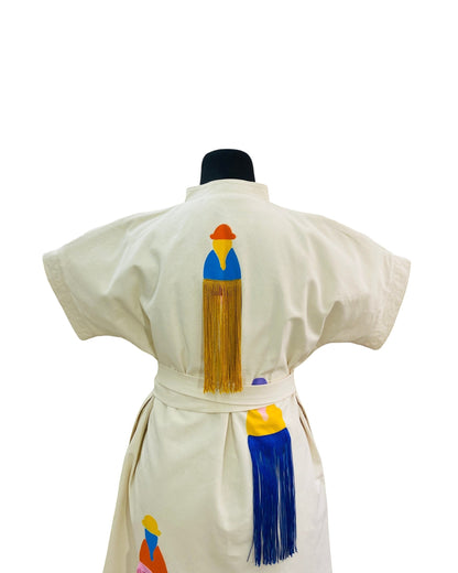 Jose Ibarra Estudio cream cotton dress with hand-painted Andean figures and colorful fringe details. Belted waist.
