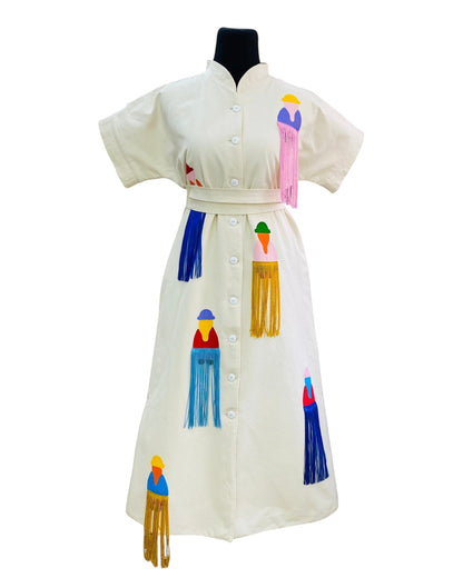 jose ibarra estudio cream cotton dress with hand-painted Andean figures and colorful fringe details.