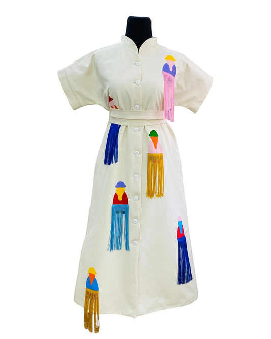 jose ibarra estudio cream cotton dress with hand-painted Andean figures and colorful fringe details.