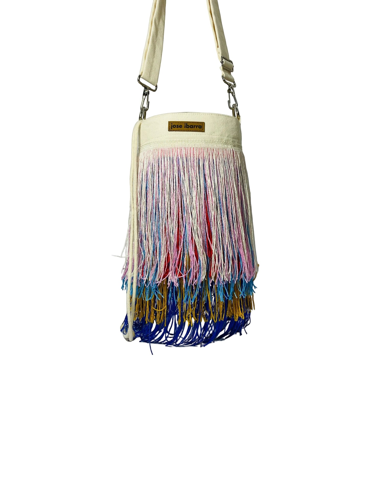 Jose Ibarra Estudio cream cotton bucket bag with multi-colored fringe detailing and adjustable strap.