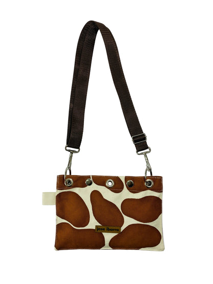 Jose Ibarra Estudio brown and cream giraffe print canvas pouch with adjustable strap and internal lining.