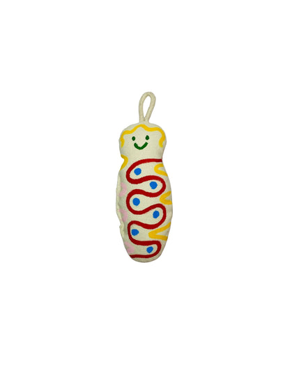 Jose Ibarra Estudio cream cotton keychain with hand-painted abstract red, yellow, pink, and blue wavy design and a smiling face.