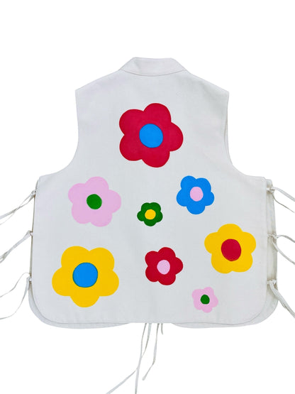 Jose Ibarra Estudio white 100% cotton canvas vest, hand-painted with colorful floral motifs. Features a collar and adjustable tie sides.