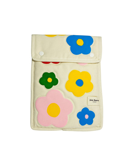 Jose Ibarra Estudio cream canvas iPad sleeve with a colorful hand-painted floral pattern in pink, blue, yellow, and green.