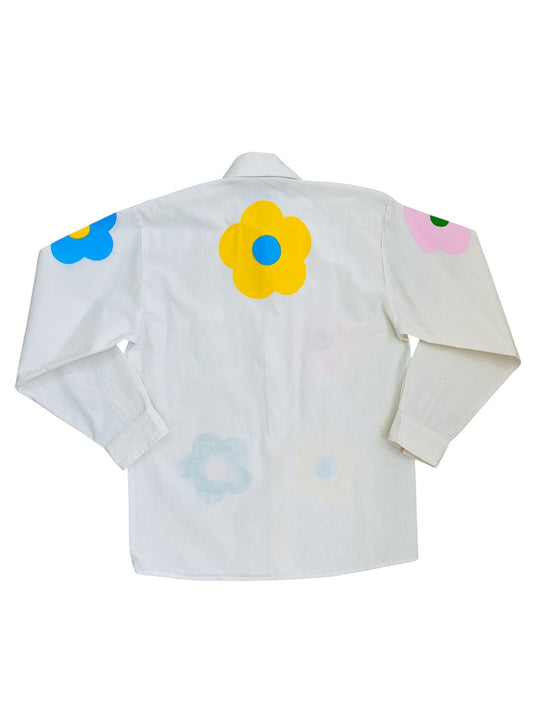 Jose Ibarra Estudio white 100% cotton loose-fit shirt with hand-painted pastel flowers in yellow, blue, pink, and light blue.