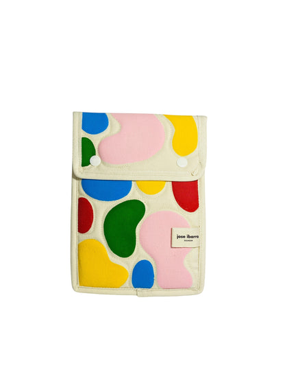 Jose Ibarra Estudio cream canvas iPad sleeve with colorful abstract hand-painted shapes. Features snap closure and internal lining.