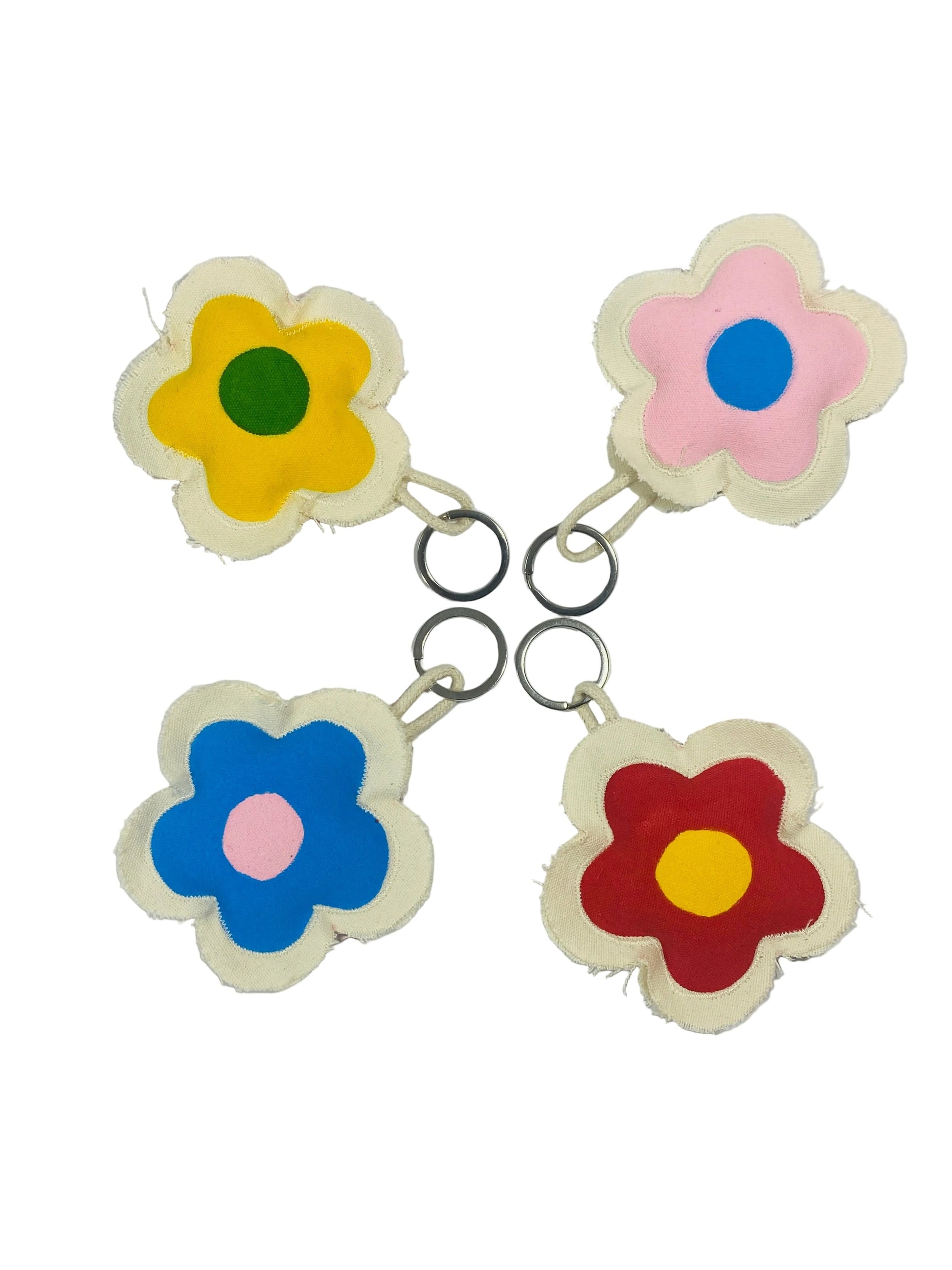 Jose Ibarra Estudio handmade flower keychains in yellow, pink, blue, and red with contrasting centers, made of thick cotton canvas.