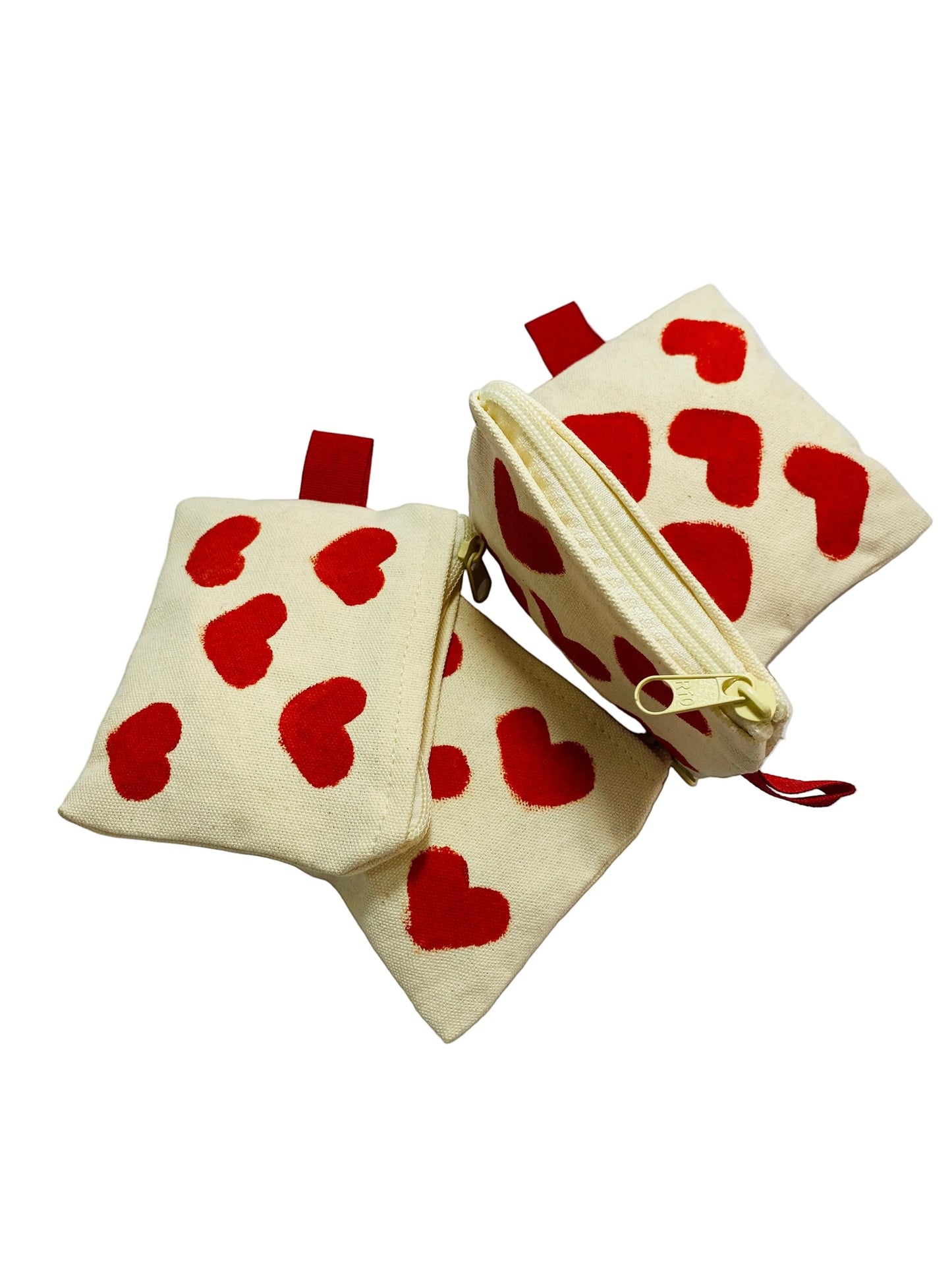 Jose Ibarra Estudio cream canvas coin purse with red hand-painted hearts, zipper closure, and red loop detail.