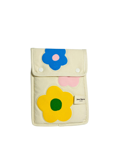 Jose Ibarra Estudio cream cotton iPad sleeve with hand-painted floral appliques in blue, yellow, and pink.