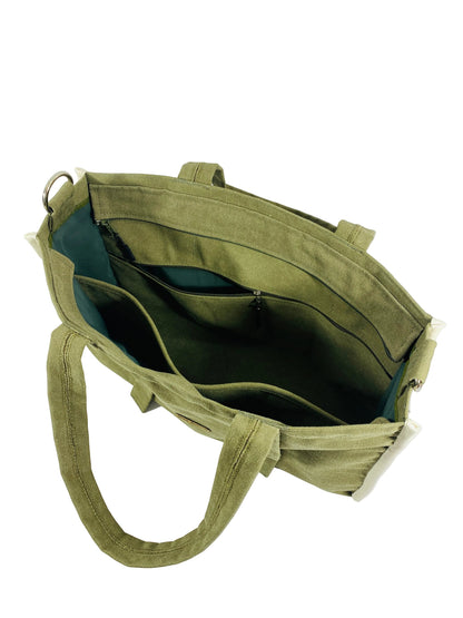 Jose Ibarra Estudio olive green canvas tote bag with multiple internal pockets and a detachable strap. Features thick canvas and a contrasting white trim.