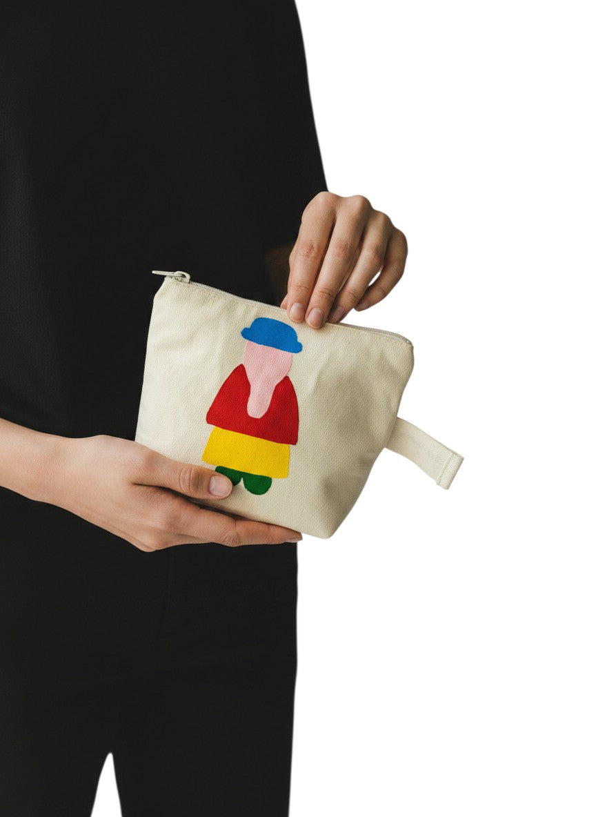 Jose Ibarra Estudio cream cotton cosmetic bag with hand-painted abstract figure in blue, pink, red, yellow, and green.