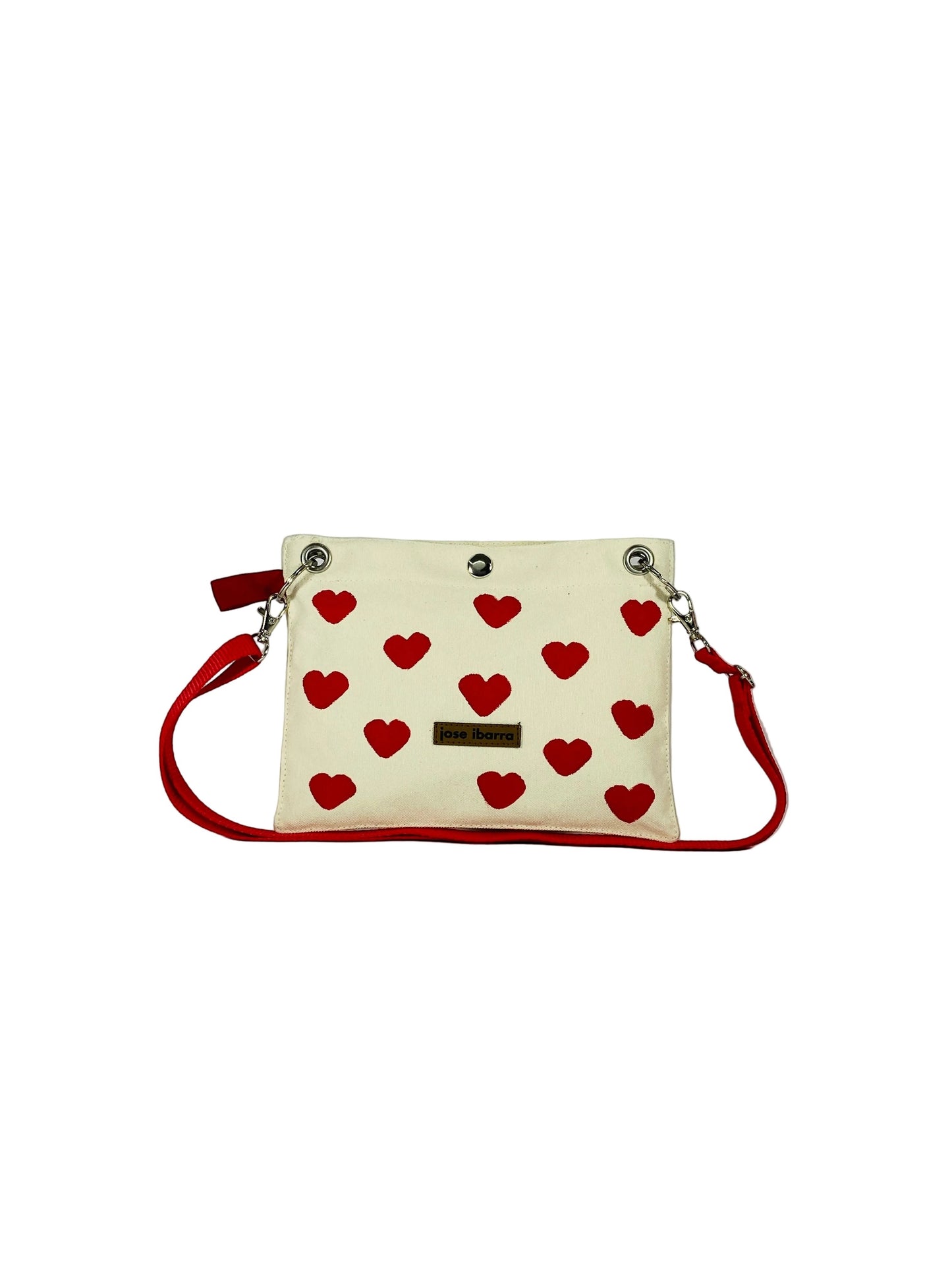 Jose Ibarra Estudio cream canvas pouch with red hearts, red trim, and red strap. Includes internal lining.