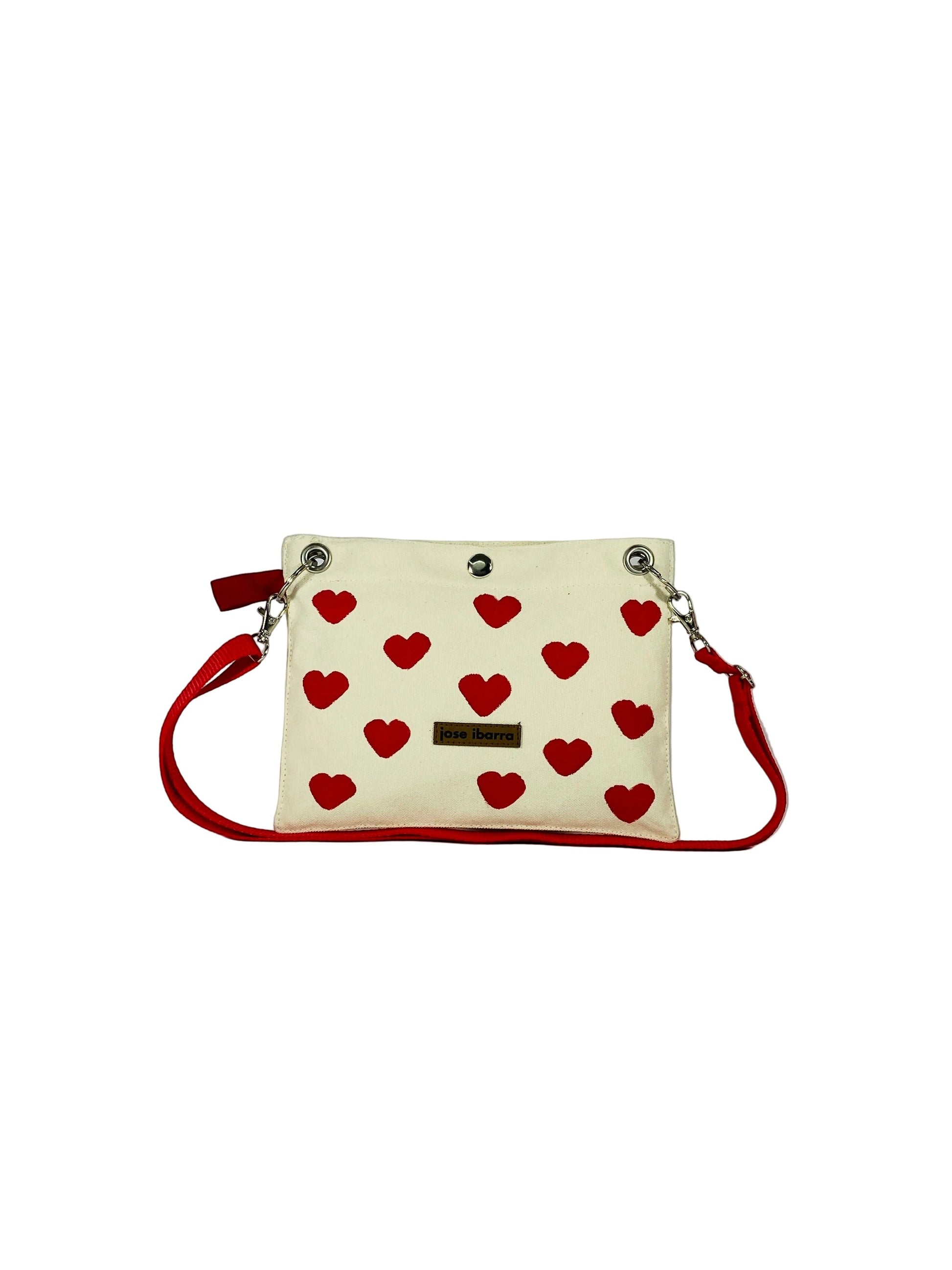 Jose Ibarra Estudio cream canvas pouch with red hearts, red trim, and red strap. Includes internal lining.