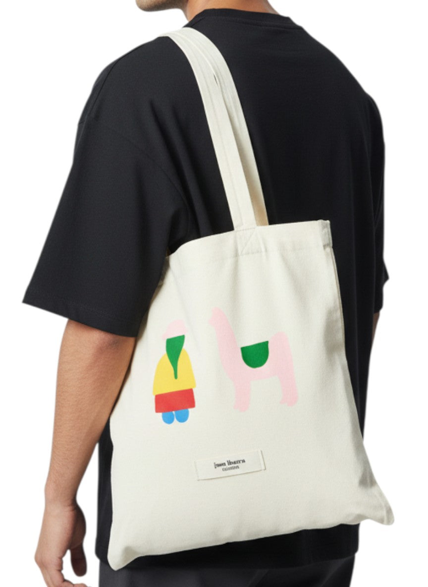 Jose Ibarra Estudio cream cotton tote bag with hand-painted figures of a person and a llama in colorful abstract style.