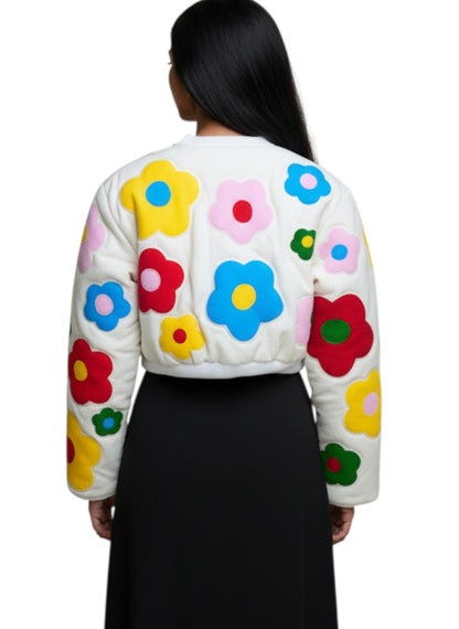 Jose Ibarra Estudio white quilted jacket with colorful hand-painted floral appliques, long sleeves, and cropped fit.