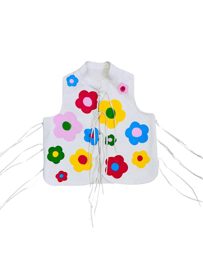 Jose Ibarra Estudio white 100% cotton canvas vest, hand-painted with colorful flowers, featuring a tie front and adjustable side ties.