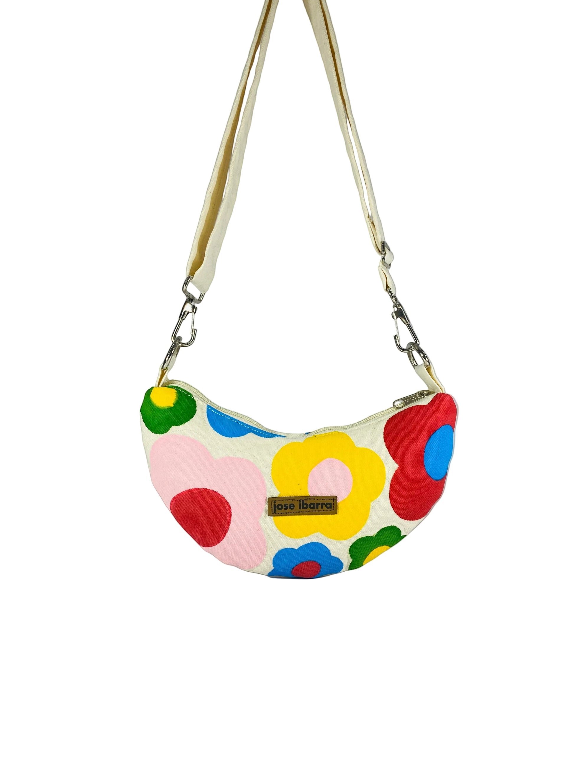 Jose Ibarra Luna cream canvas crossbody bag with hand-painted colorful floral pattern and adjustable strap.
